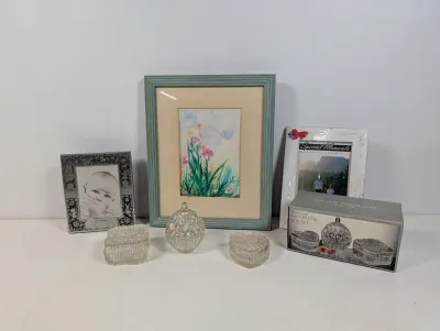 Sale Photo Thumbnail #104: Collection of decorative tabletop items, including three picture frames, a floral artwork, and a three-piece set of cut crystal trinket boxes with original box.