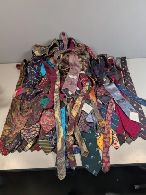 Sale Photo Thumbnail #42: Large assortment of vintage men's neckties, featuring a variety of colorful patterns including paisley, geometric, stripes, and novelty prints.