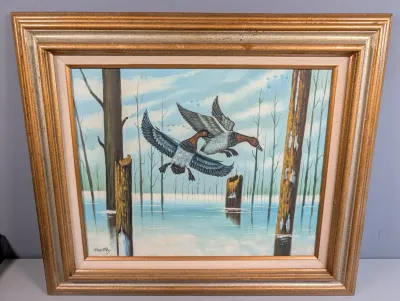 Sale Photo Thumbnail #15: Framed oil painting on canvas depicting two ducks in flight over a wetland, signed Huntley in the lower left corner and set in a metallic gold-finished wooden frame.