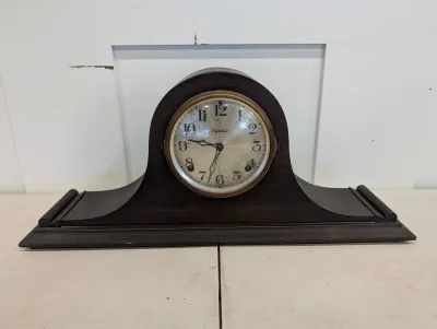Sale Photo Thumbnail #485: Antique Ingraham tambour mantle clock in a dark wood case with brass dial bezel, early 20th century.