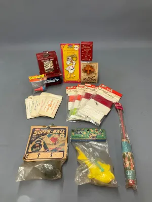 Sale Photo Thumbnail #357: Collection of vintage mid-century novelty items and toys, including a Wham-O Super-Ball in original packaging, a Donald Duck keychain, a toy chocolate bank, and Plexon craft strips.