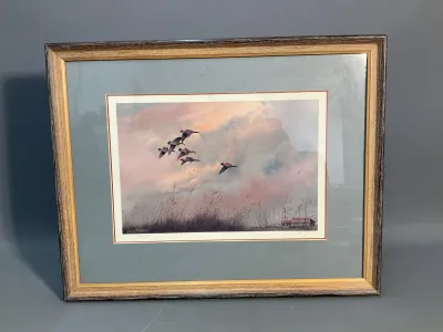 Sale Photo Thumbnail #168: Framed wildlife art print depicting geese in flight over a marsh at sunset, presented in a double mat and a two-tone wooden frame.