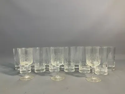 Sale Photo Thumbnail #53: Large collection of mid-century etched glass drinkware, including wine goblets and highball glasses featuring subtle geometric and botanical patterns.