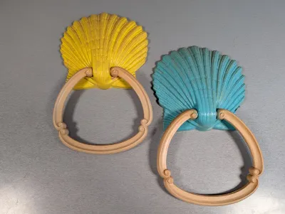 Sale Photo Thumbnail #197: Pair of vintage seashell towel rings in yellow and turquoise with beige resin rings.