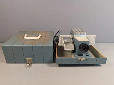 Sale Photo Thumbnail #371: Vintage Bell & Howell Project-o-View 300 slide projector with its original blue carrying case.
