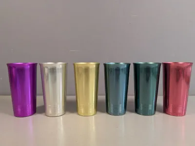 Sale Photo Thumbnail #278: Set of six vintage anodized aluminum tumblers in assorted jewel tones, featuring horizontal ridge details around the base, circa 1950s.