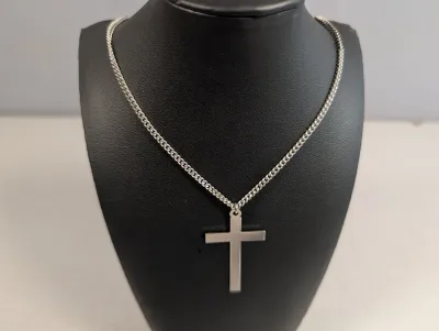 Sale Photo Thumbnail #397: Silver-tone cross pendant necklace with a curb link chain, displayed on a black jewelry bust.