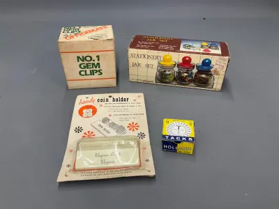 Sale Photo Thumbnail #333: Collection of vintage office supplies, including an Officemate Gem Clips box, a three-piece stationery jar set, a packaged handy coin holder souvenirs from Virginia Beach, and a small box of Holland tacks.