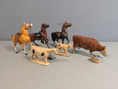 Sale Photo Thumbnail #394: Collection of vintage plastic farm animal figurines, including three saddled horses, cows, calves, and a miniature milker can.