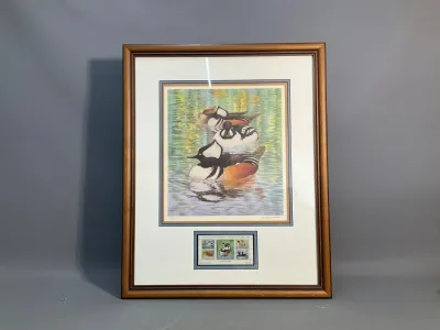 Sale Photo Thumbnail #148: Framed and matted wildlife art print featuring hooded mergansers on water with a set of commemorative duck stamps display inset below.