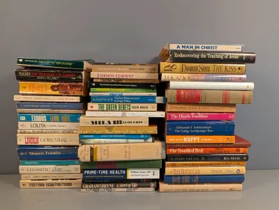 Sale Photo Thumbnail #239: Large collection of vintage paperback and hardcover books arranged in three stacks, covering fiction, history, religion, and biography titles.