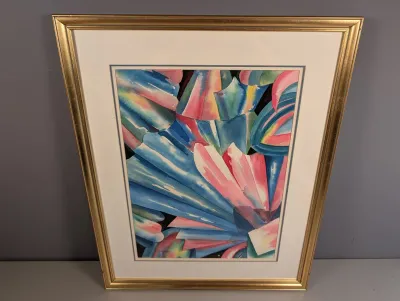Sale Photo Thumbnail #443: Framed watercolor print featuring abstract colorful fan and leaf motifs in shades of blue, pink, and yellow, presented in a gold-finished frame.
