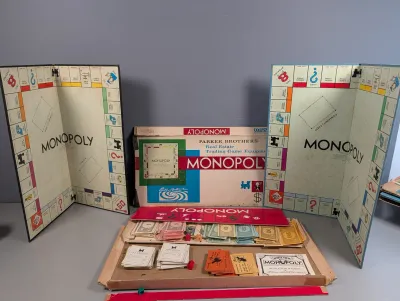Sale Photo Thumbnail #228: Vintage Monopoly board game sets by Parker Brothers, including two game boards, play money, property cards, chance/community chest cards, and instruction booklet.