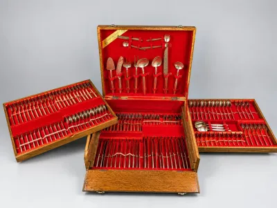 Sale Photo Thumbnail #33: Extensive vintage flatware set housed in a large wooden chest with red felt-lined interior compartments and removable trays.