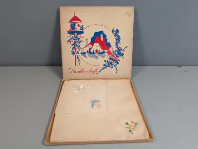 Sale Photo Thumbnail #412: Vintage set of embroidered ladies' handkerchiefs in their original presentation box, featuring red and blue cottage graphic lid art.