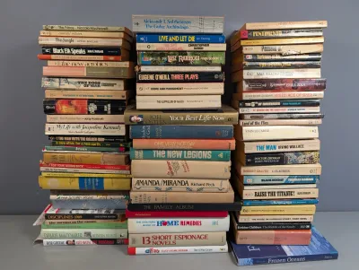 Sale Photo Thumbnail #243: Large collection of vintage paperback and hardcover books arranged in tall stacks, spanning genres such as fiction, classics, history, and self-help.