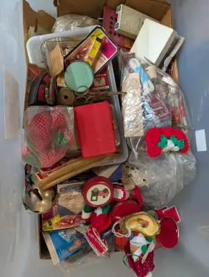 Sale Photo Thumbnail #418: Cardboard box and plastic bin filled with vintage sewing notions, crafting supplies, small tin containers, and holiday ornaments.