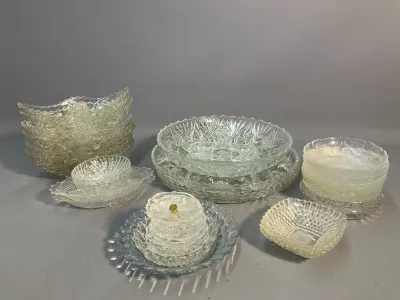 Sale Photo Thumbnail #62: Collection of vintage clear pressed and cut glass tableware, including serving bowls, small dishes, and stacked plates in various geometric and textured patterns.