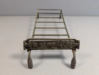 Sale Photo Thumbnail #381: Vintage Griswold cast iron and wire stove rack or roaster insert, featuring embossed branding and a distressed patina.