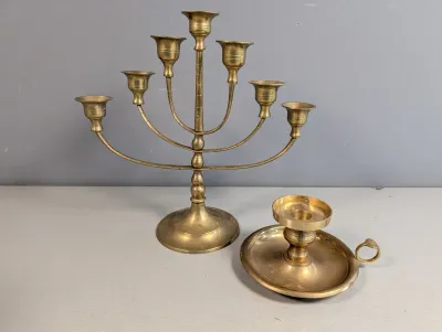 Sale Photo Thumbnail #44: Seven-arm brass menorah candelabra alongside a matching brass chamberstick candle holder, showing light patina.