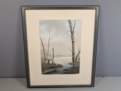 Sale Photo Thumbnail #450: Framed original landscape painting featuring birds in flight over a muted wetland scene with bare trees, signed by the artist in the lower left corner.