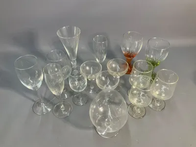 Sale Photo Thumbnail #65: Assorted vintage stemware and glassware collection, featuring champagne flutes, wine glasses, coupe glasses, and a large snifter.