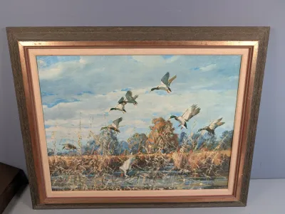 Sale Photo Thumbnail #469: Framed oil painting depicting mallard ducks in flight over a wetland landscape, set in a layered wooden and gilded frame.