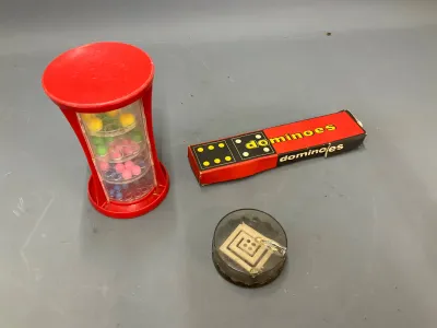 Sale Photo Thumbnail #335: Vintage game lot including a plastic tower puzzle game, a boxed set of miniature dominoes, and a small round dexterity maze puzzle.