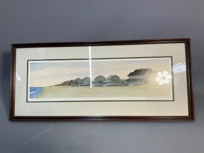 Sale Photo Thumbnail #142: Framed panoramic print depicting beach houses along the coastline, housed in a dark wooden frame with double matting.