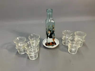 Sale Photo Thumbnail #68: Novelty miniature decanter featuring a waiter graphic resting on a dish tray, surrounded by eight small clear glass cordial cups.