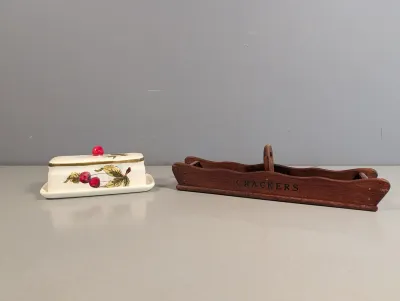 Sale Photo Thumbnail #389: Vintage ceramic cherry-patterned covered butter dish alongside a wooden table caddy labeled 'CRACKERS'.