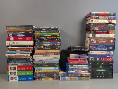 Sale Photo Thumbnail #51: Large collection of media including DVDs, Blu-rays, and VHS tapes, featuring various movie titles, TV shows, and box sets.