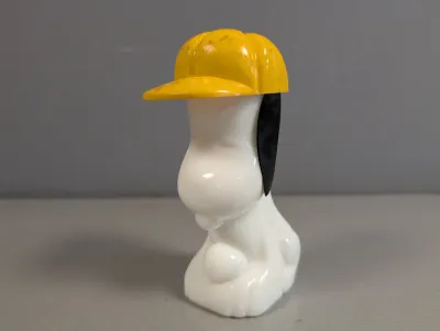 Sale Photo Thumbnail #301: Vintage Avon Peanuts Snoopy plastic bubble bath bottle featuring a yellow baseball cap, showing light wear.