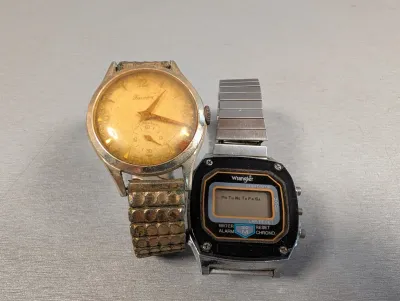 Sale Photo Thumbnail #413: Pair of vintage wristwatches including a heavily aged Luxory antimagnetic mechanical watch with a sub-dial and a retro digital Wrangler watch with a stainless steel band.