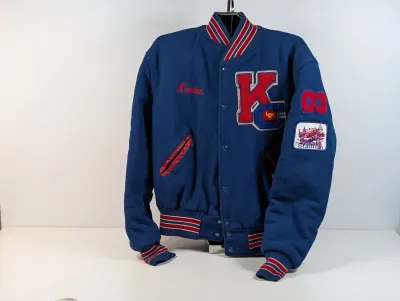 Sale Photo Thumbnail #91: Vintage blue wool letterman jacket with red and white striped ribbed trim, featuring a 'KC' chenille patch, embroidered name 'Kristen', and sleeve patches.