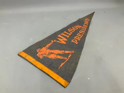 Sale Photo Thumbnail #349: Vintage felt pennant for 'Wilson Presidents' featuring an orange football player graphic printed on dark blue wool with orange trim.
