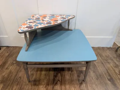 Sale Photo Thumbnail #470: Mid-century modern two-tier corner step end table featuring a painted light blue lower shelf and a colorful retro geometric circle pattern top surface.