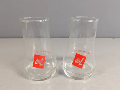 Sale Photo Thumbnail #257: Pair of vintage 1970s 7Up "The Uncola" clear glass hurricane-style tumblers featuring upside-down red logos.
