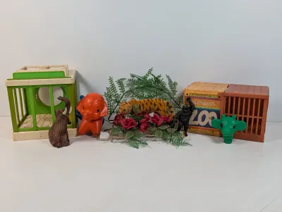 Sale Photo Thumbnail #109: Vintage collection of Playskool Zoo toy structures and plastic animal figurines, including an elephant, tiger, gorilla, and cages.
