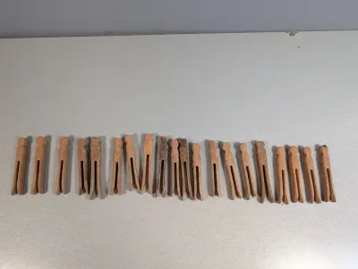 Sale Photo Thumbnail #224: Collection of vintage flat-headed, one-piece wooden clothespins showing minor age-related wear.