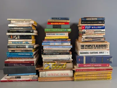 Sale Photo Thumbnail #296: Three large stacks of assorted vintage and contemporary hardcover and paperback books, including titles on fiction, cooking, religion, and crafts.