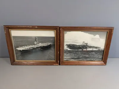 Sale Photo Thumbnail #459: Pair of framed mid-century black and white military photographs depicting aircraft carriers at sea, housed in matching dark wood frames with gold fillets.