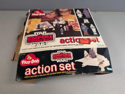 Sale Photo Thumbnail #309: Vintage 1980 Kenner Play-Doh Star Wars: The Empire Strikes Back Action Set in original box, showing significant edge wear and damage to the top corner.