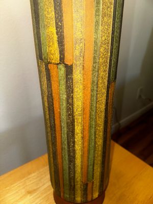 Sale Photo Thumbnail #37: Close-up view of a mid-century ceramic lamp base featuring textured vertical stripes in shades of green, yellow, orange, and brown.
