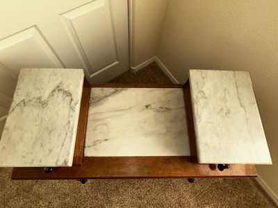 Sale Photo Thumbnail #27: Top view of a vintage wooden side table featuring a white-and-gray veined marble insert and stepped top surfaces.