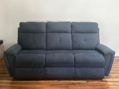 Sale Photo Thumbnail #32: Contemporary dark gray upholstered reclining three-cushion sofa in clean condition.