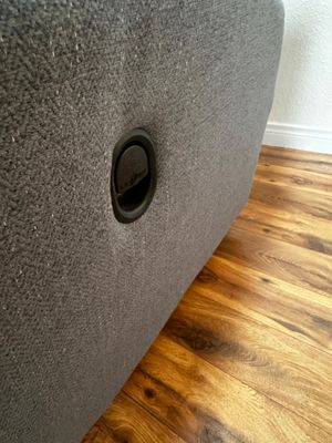 Sale Photo Thumbnail #31: Detail view of a modern grey fabric La-Z-Boy recliner showing the black release handle mechanism.