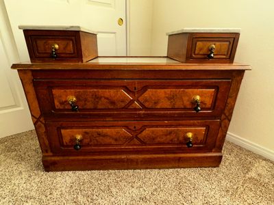 Sale Photo Thumbnail #26: Antique burl wood dresser featuring decorative drop handles and twin marble-topped jewel drawers.