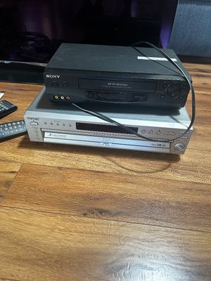 Sale Photo Thumbnail #48: Black Sony Hi-Fi Stereo VCR stacked on top of a silver Sony 5-disc DVD changer player, circa 2000s.