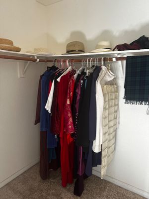 Sale Photo Thumbnail #68: Selection of women's clothing, hats, and accessories displayed inside a walk-in closet.